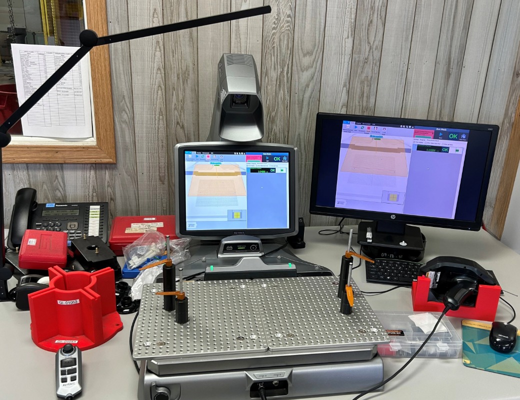 A Keyence XM Series handheld CMM (Coordinate Measuring Machine) station at Guttenberg Industries, used for high-precision 3D measurements of complex plastic parts.